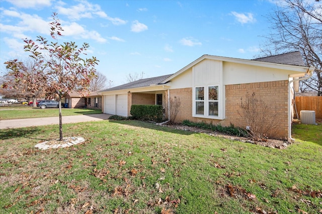 ranch-style house featuring a garage, central air condition unit, and a front yard