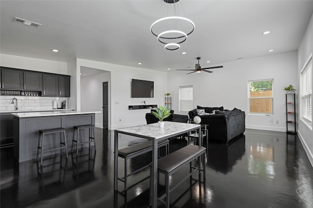 interior space featuring ceiling fan with notable chandelier