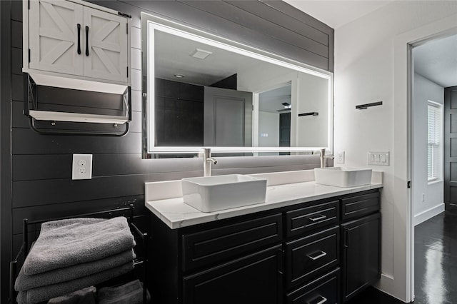 bathroom featuring wood walls and vanity