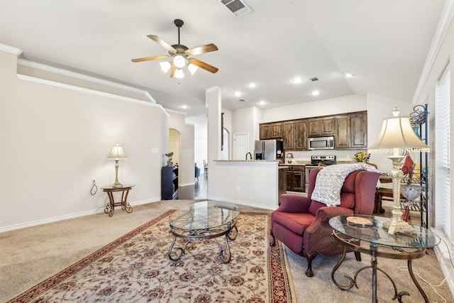 living room with ceiling fan, crown molding, and light colored carpet