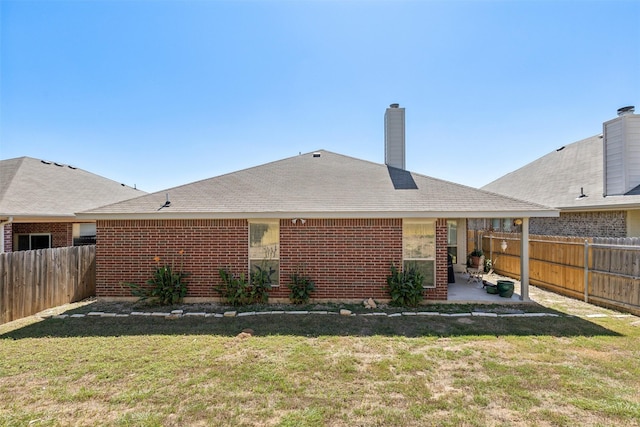 back of house featuring a lawn and a patio