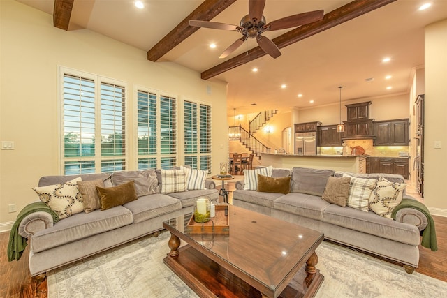 living room featuring beam ceiling, light hardwood / wood-style flooring, and ceiling fan