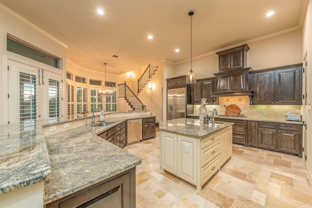 kitchen featuring sink, tasteful backsplash, decorative light fixtures, stainless steel appliances, and cream cabinetry