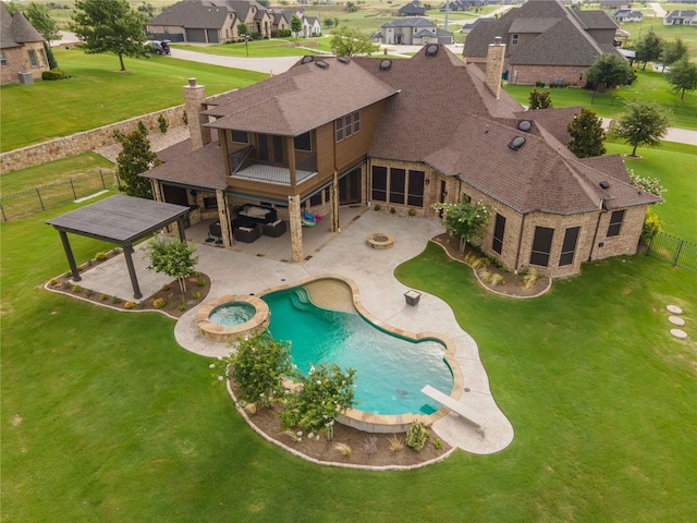 view of swimming pool with a yard, a patio area, a diving board, and an in ground hot tub