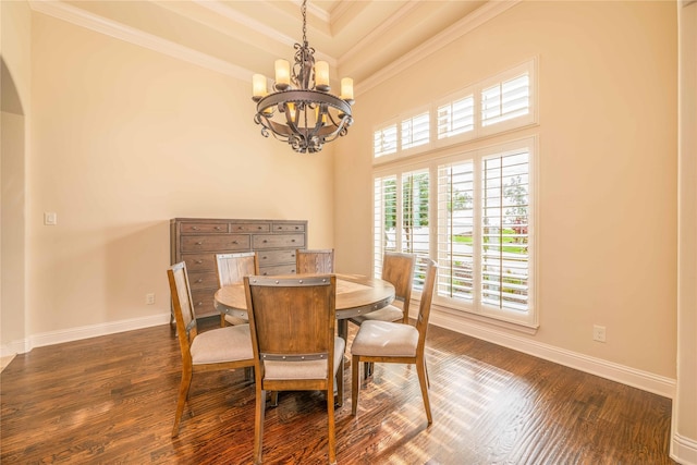 dining space with dark hardwood / wood-style flooring, crown molding, and a raised ceiling