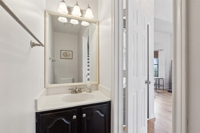 bathroom with vanity, wood-type flooring, a textured ceiling, and toilet