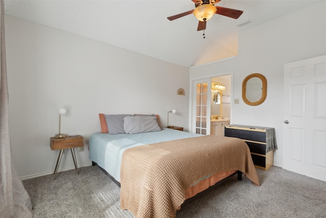 bedroom featuring dark colored carpet, ceiling fan, vaulted ceiling, and ensuite bath