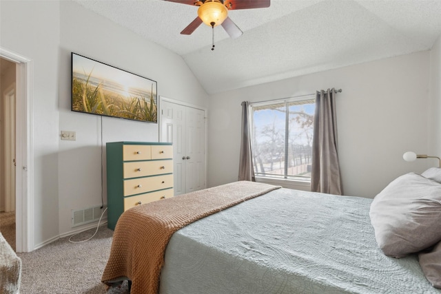 bedroom featuring a textured ceiling, ceiling fan, carpet, and vaulted ceiling