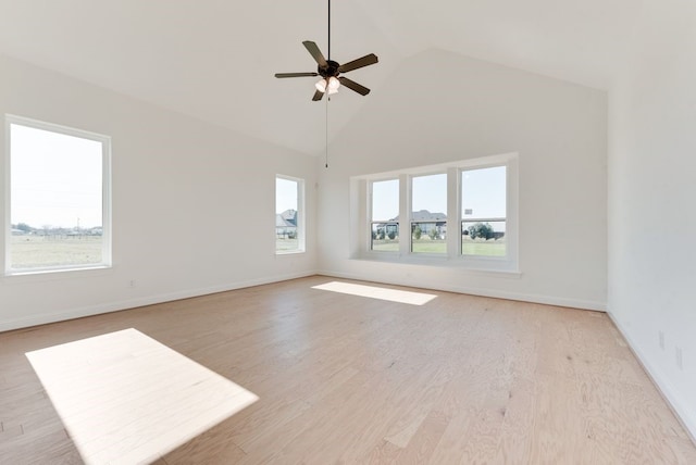 empty room with ceiling fan, high vaulted ceiling, and light wood-type flooring