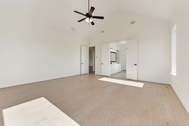 empty room with ceiling fan, light wood-type flooring, and high vaulted ceiling