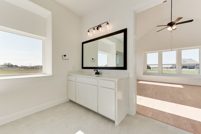 bathroom with ceiling fan, vanity, and vaulted ceiling