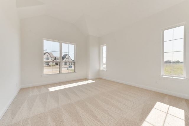 empty room featuring lofted ceiling and light colored carpet