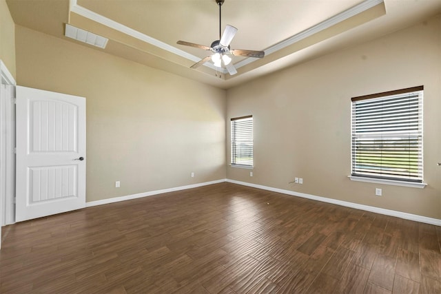 unfurnished room featuring dark hardwood / wood-style floors, a raised ceiling, ceiling fan, and ornamental molding