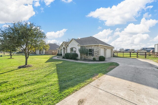 french country style house featuring a garage and a front yard