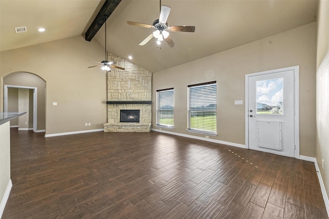 unfurnished living room featuring dark wood-type flooring, high vaulted ceiling, ceiling fan, a fireplace, and beam ceiling