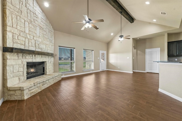 unfurnished living room with high vaulted ceiling, a stone fireplace, ceiling fan, beamed ceiling, and dark hardwood / wood-style flooring