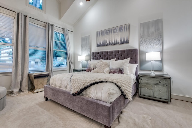 bedroom with light carpet and high vaulted ceiling