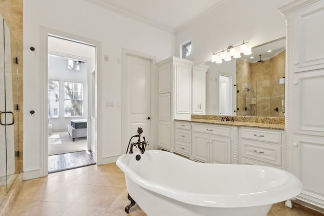 bathroom with tile patterned flooring, vanity, separate shower and tub, and crown molding