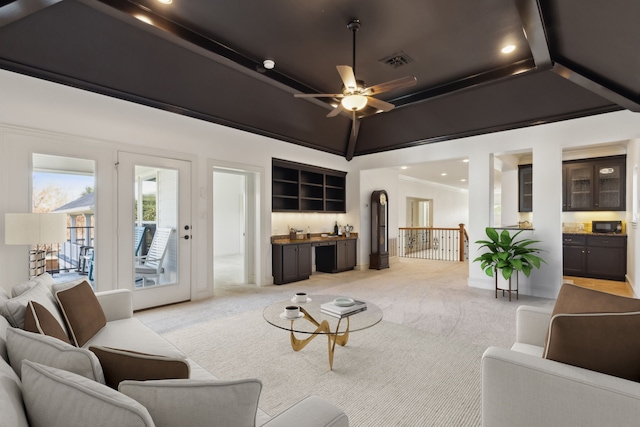 living room with ceiling fan, light carpet, and indoor bar