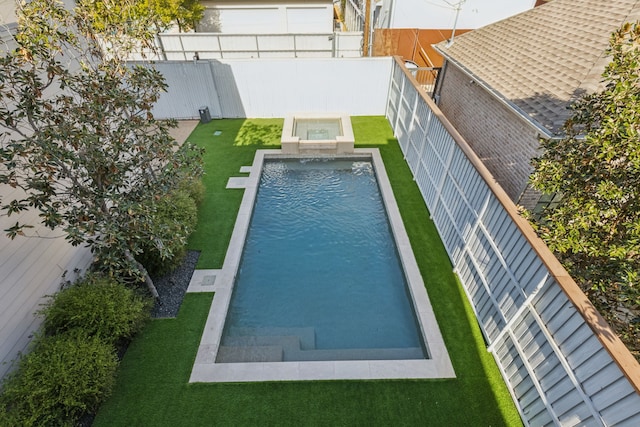 view of swimming pool with a hot tub and a lawn