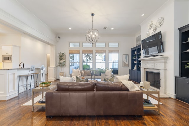 living room featuring ornamental molding, dark wood-type flooring, and an inviting chandelier