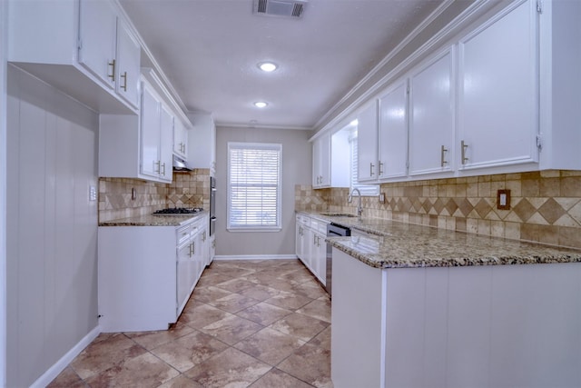 kitchen featuring sink, appliances with stainless steel finishes, light stone countertops, white cabinets, and decorative backsplash