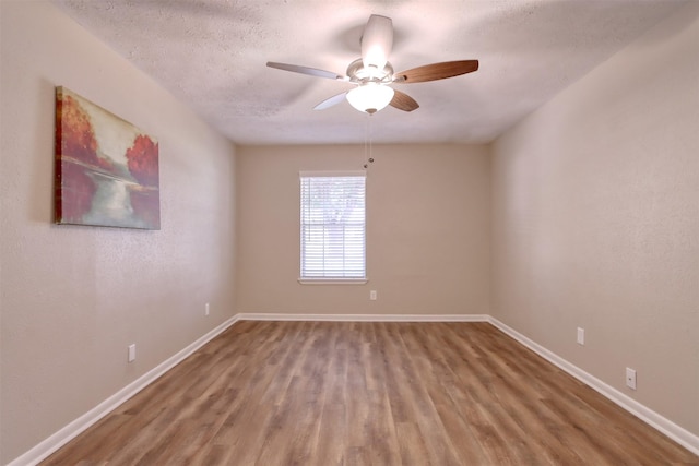 spare room featuring ceiling fan, wood-type flooring, and a textured ceiling