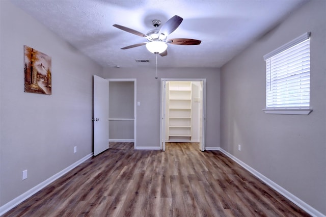 unfurnished bedroom featuring hardwood / wood-style flooring, a closet, and ceiling fan