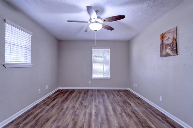 empty room with a textured ceiling, dark hardwood / wood-style floors, and ceiling fan