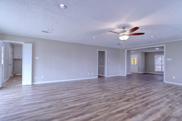 spare room with wood-type flooring, ceiling fan, and a textured ceiling