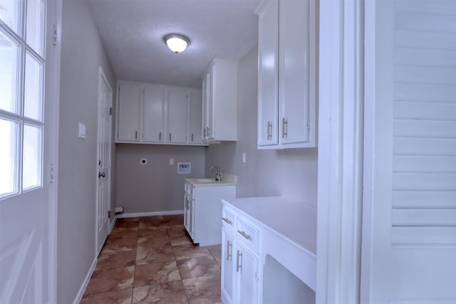 clothes washing area with sink, cabinets, a textured ceiling, hookup for a washing machine, and electric dryer hookup