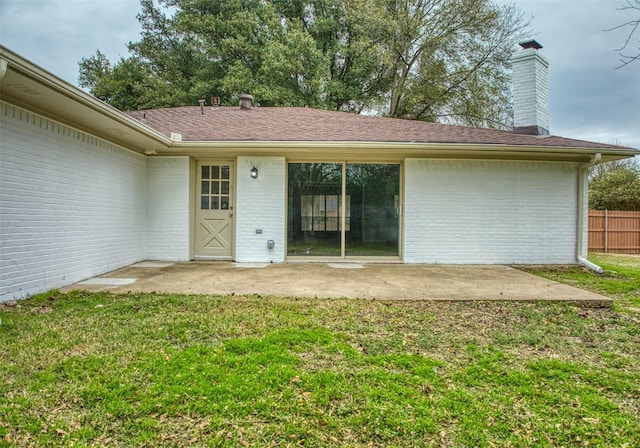 rear view of house featuring a patio area and a lawn