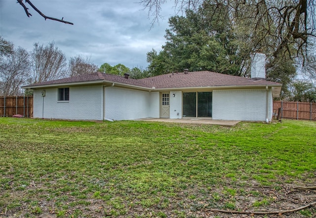 rear view of property with a patio and a lawn