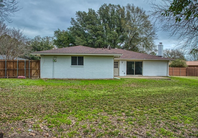 rear view of property featuring a yard and a patio