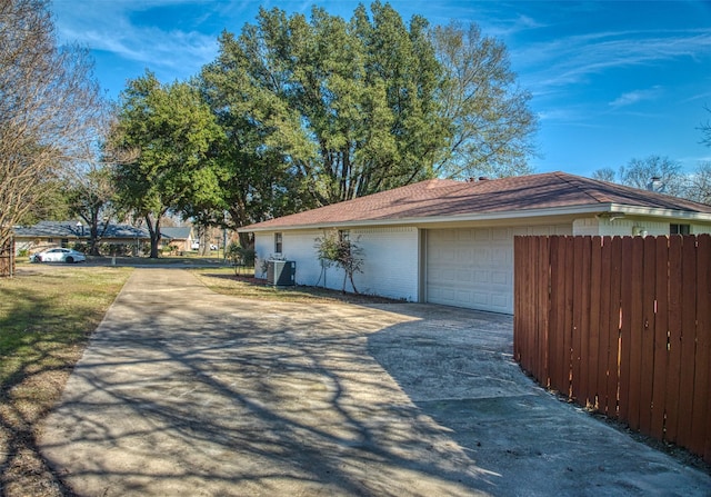 exterior space with a garage and central air condition unit