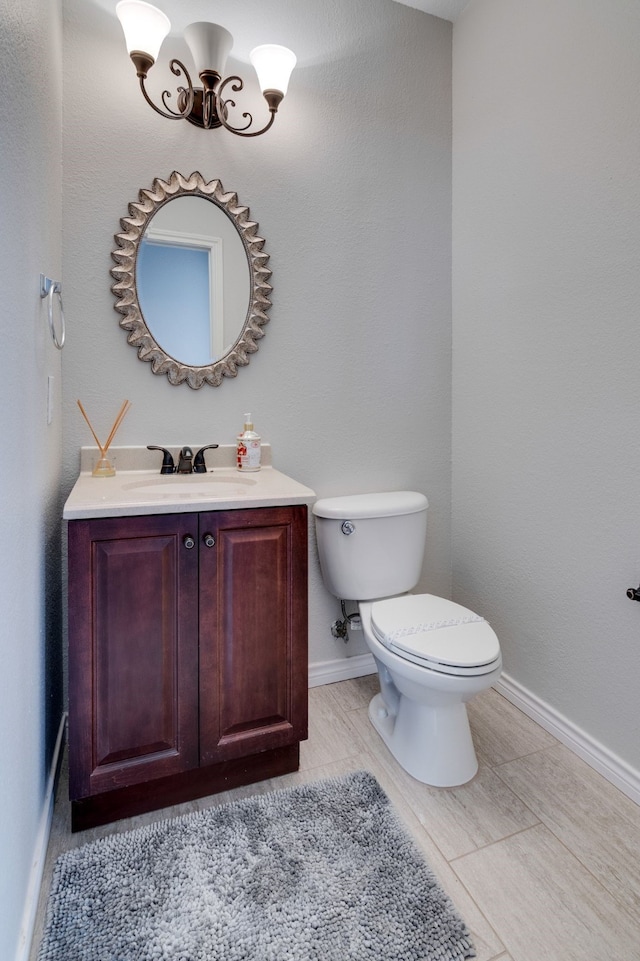 bathroom featuring vanity, toilet, and a notable chandelier