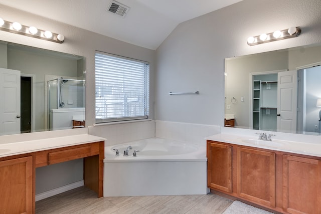 bathroom featuring separate shower and tub, vanity, and vaulted ceiling