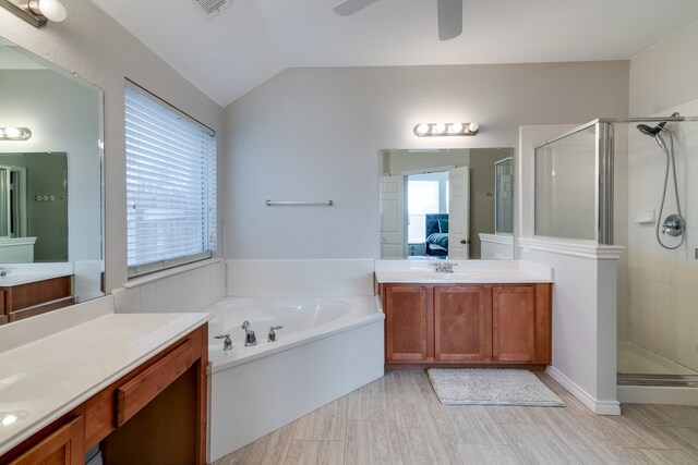 bathroom featuring vanity, separate shower and tub, vaulted ceiling, and plenty of natural light