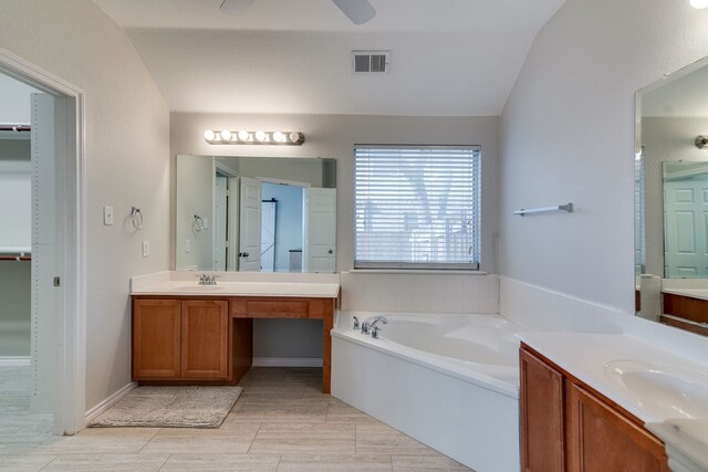 bathroom with a washtub, lofted ceiling, and vanity