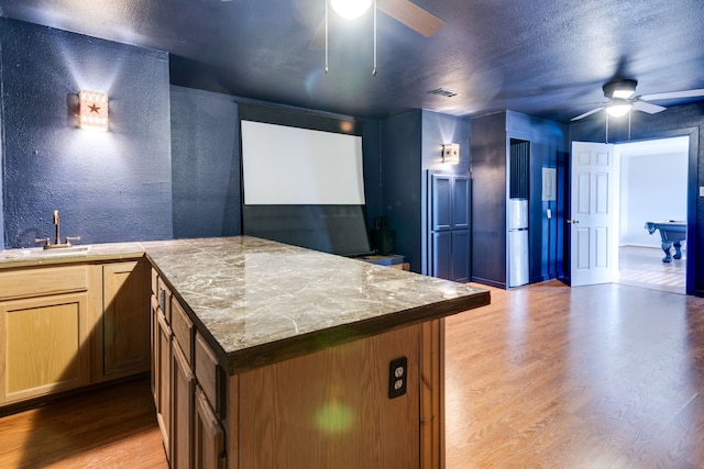 kitchen featuring ceiling fan, light wood-type flooring, sink, and pool table