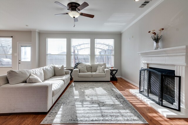 living room with hardwood / wood-style floors, ceiling fan, and crown molding