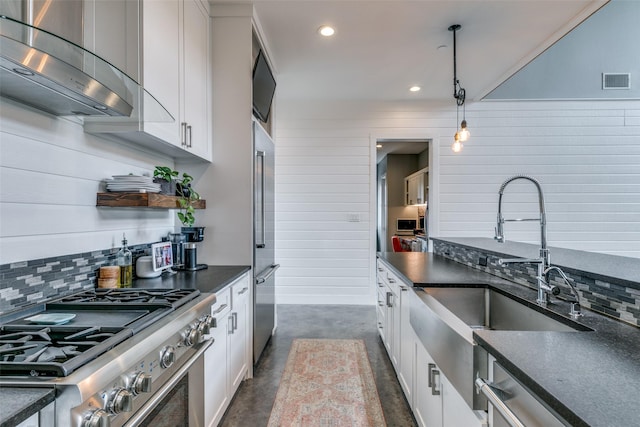 kitchen with ventilation hood, sink, pendant lighting, high quality appliances, and white cabinetry