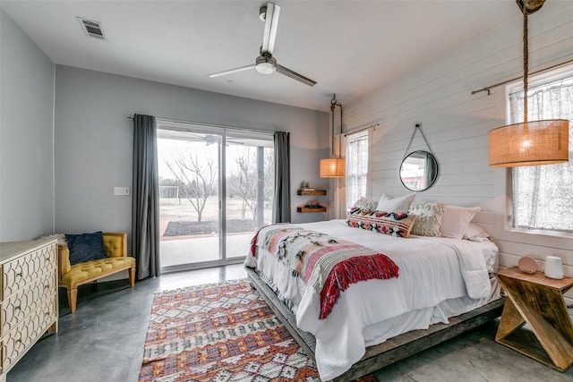 bedroom with access to exterior, ceiling fan, and wood walls