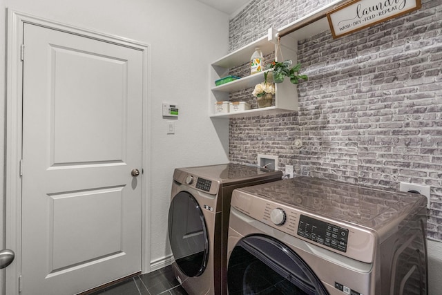 clothes washing area with dark tile patterned floors and independent washer and dryer