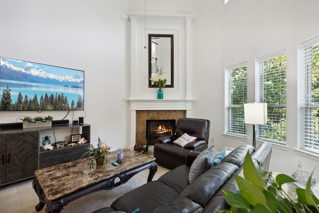 living room featuring a high ceiling, a tile fireplace, and carpet