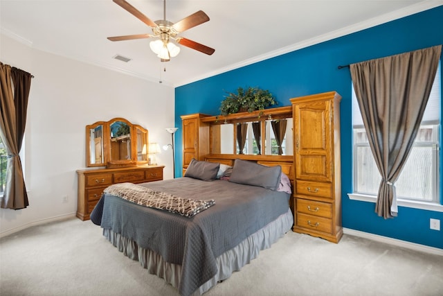 carpeted bedroom with crown molding, ceiling fan, and multiple windows