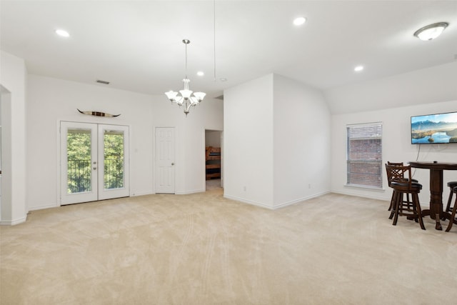 carpeted living room featuring lofted ceiling, a chandelier, and french doors