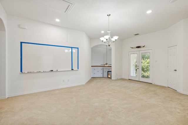 unfurnished living room featuring ceiling fan with notable chandelier and light carpet