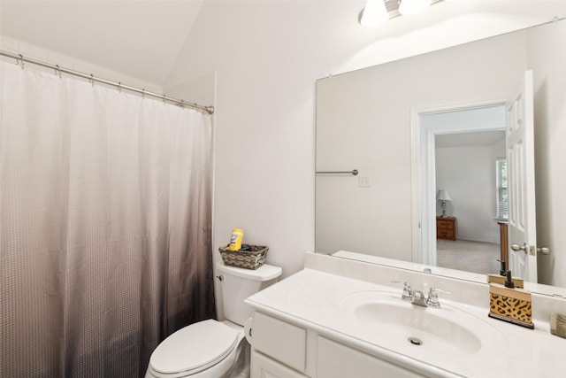 bathroom featuring vanity, lofted ceiling, and toilet