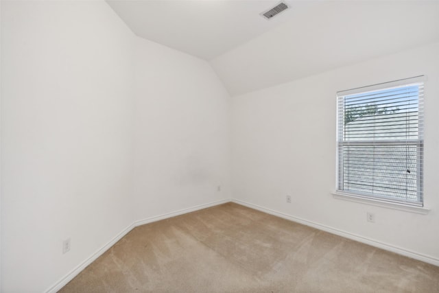 carpeted empty room featuring lofted ceiling